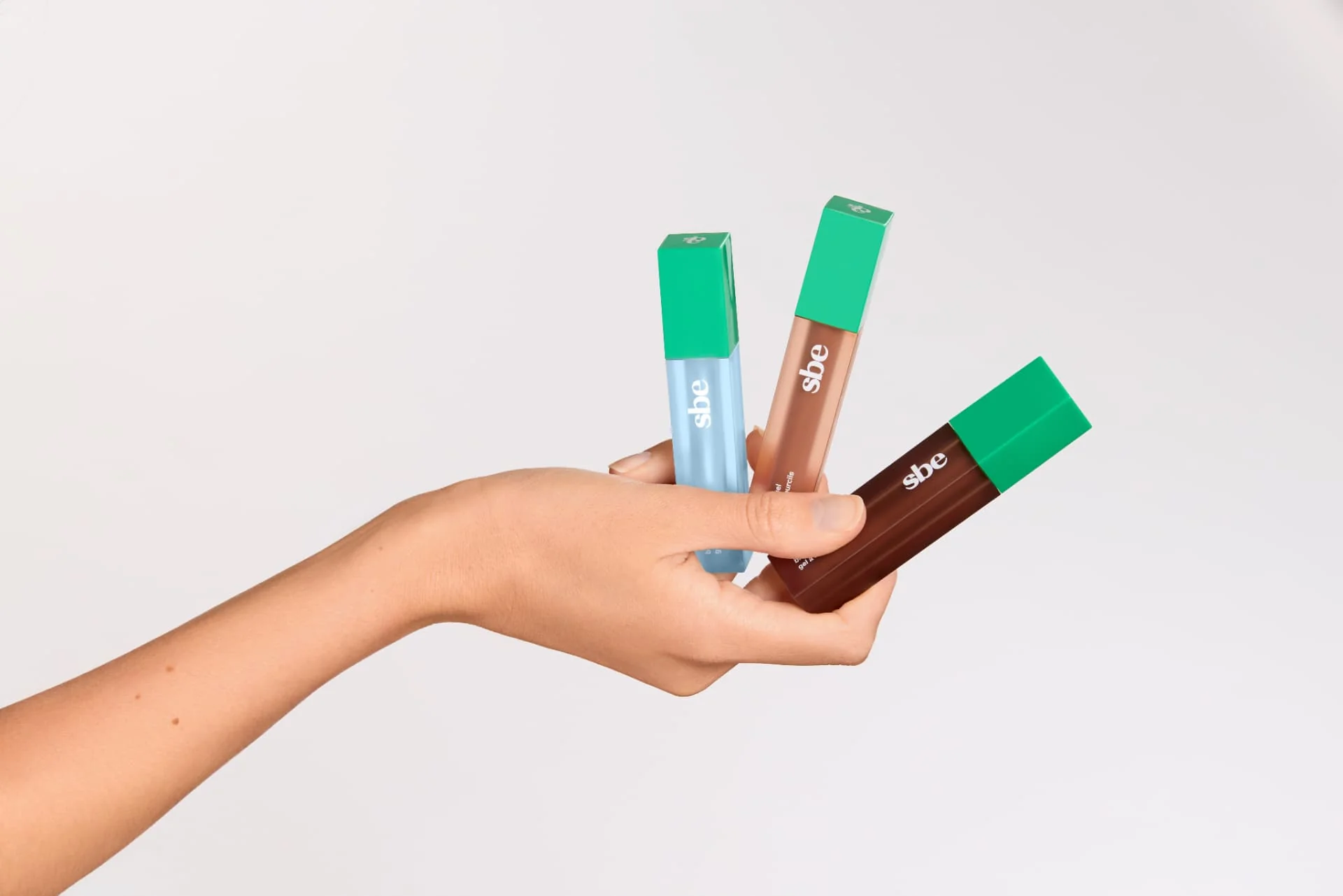 A hand holding Brow Gel in Bubble, Pebble, and Twig